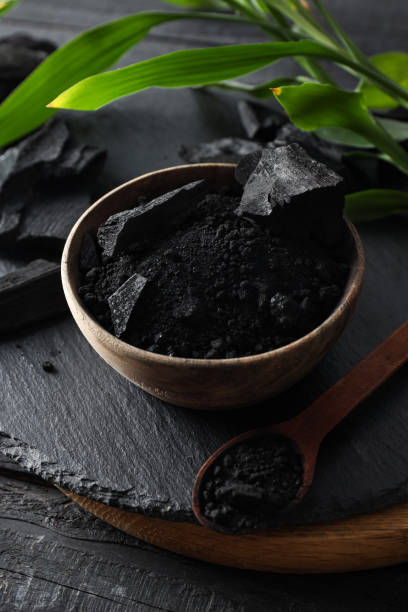 istock Natural charcoal and powdered charcoal on dark wooden background 2148171626