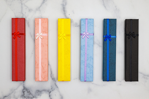 Multi colored gift boxes with bow and ribbon on marble counter.  Choose.