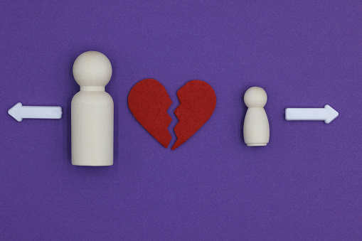 Parent and child wooden figurines experiencing heartbreak and choosing separation.
