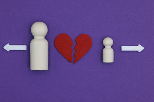 Parent and child wooden figurines experiencing heartbreak and choosing separation