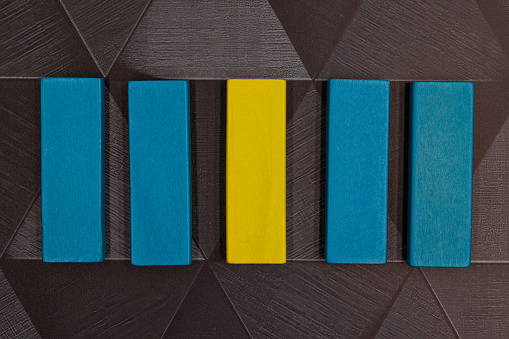 Blue and yellow blocks on a line with the yellow block standing out as the obvious choice