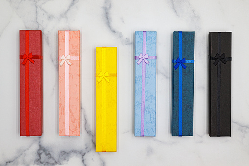 Selection of 6 Colored Gift Boxes with Bows on Marble Counter