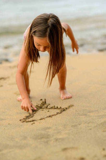 Child play with sand on beach above top drone view