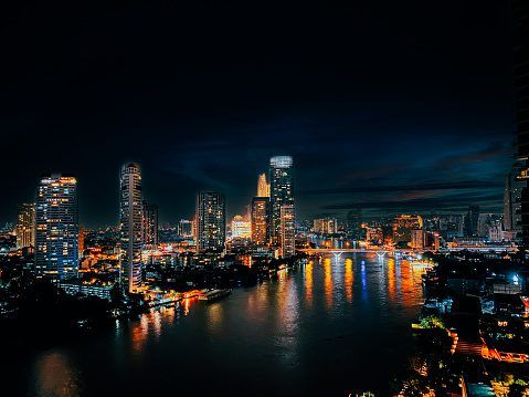 Beautiful architecture in Bangkok City skyline at night Filter effect Chao Phraya riverside at night, office buildings, Cityscape, night view in the business district at twilight capital of Thailand.
