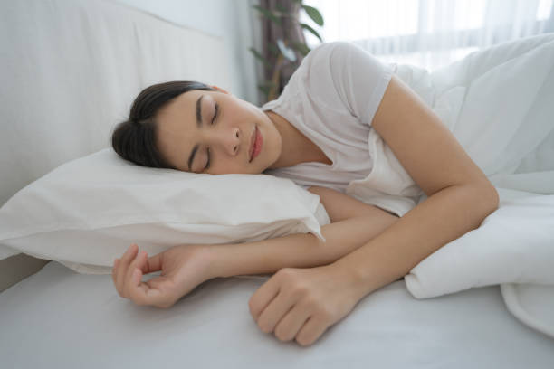 istock Young woman sleeping in a comfortable white bedroom. 2148176966