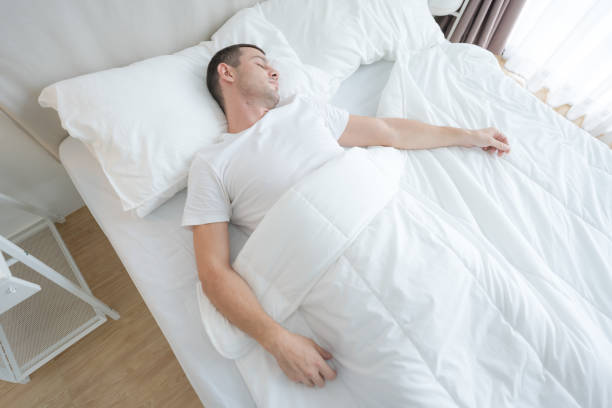 istock The young man slept in a comfortable white bedroom. 2148177201