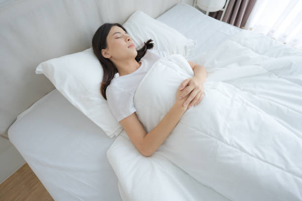 istock Young woman sleeping in a comfortable white bedroom. 2148177206