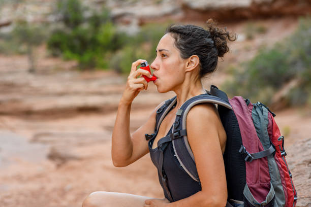 istock Female hiker rests outside to use her inhaler 2148178083