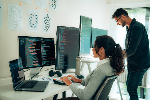 Two Hispanic Programmers Collaborating in Modern Office stock photo