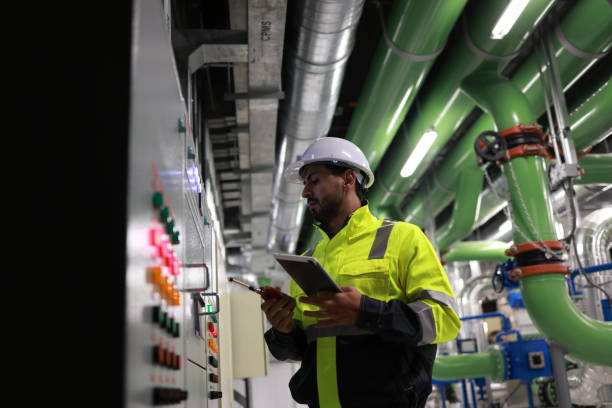istock Male electrical engineer checking and inspecting at MDB panel or Main Distribution Boards of the factory. he works with an electric switchboard to check the range of voltage and current 2148180017