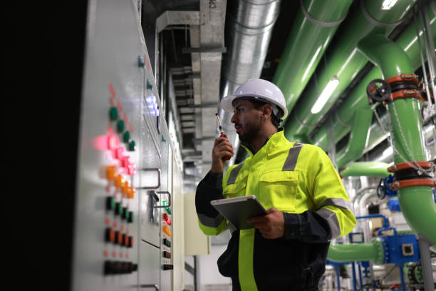 istock Male electrical engineer checking and inspecting at MDB panel or Main Distribution Boards of the factory. he works with an electric switchboard to check the range of voltage and current 2148180056