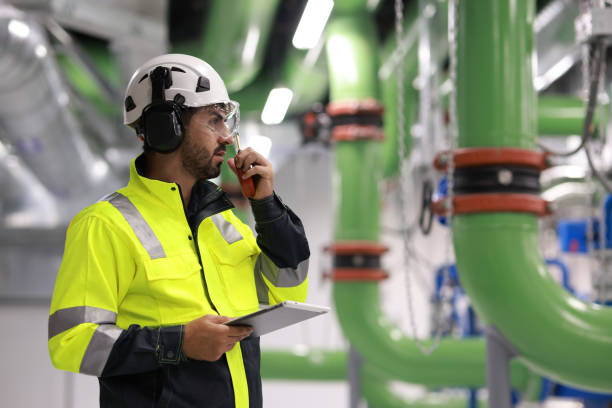 istock Male Industrial Engineers working with Project Blueprints drawing at front heavy industrial machinery, HVAC system engineer 2148180545