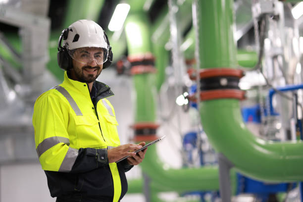 istock Male Industrial Engineers working with Project Blueprints drawing at front heavy industrial machinery, HVAC system engineer 2148180546