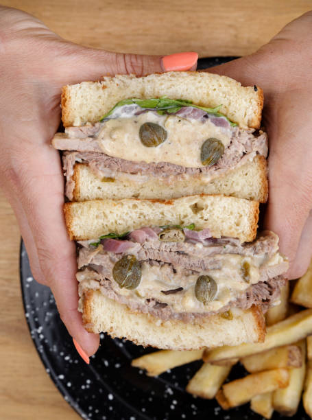 istock A woman holding a vitel tone meat sandwich 2148182327