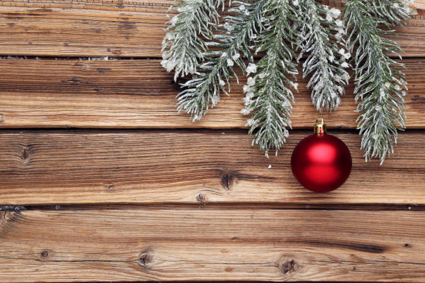 istock Red christmas bauble with fir tree branches on brown wooden background 2148184258