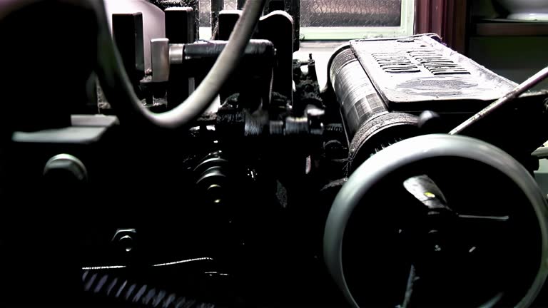 An Old Letterpress Printing Press Machine Printing Sheets of Braille Paper. Close up. 4K Resolution.