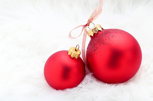 Red christmas baubles with ribbon on white background