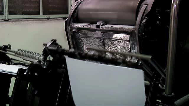 An Old Letterpress Printing Press Machine Printing Sheets of Braille Paper. Close up. 4K Resolution.