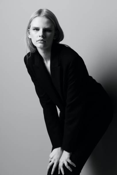 istock Young beautiful stylish girl posing leaning on the wall in the studio 2148185302