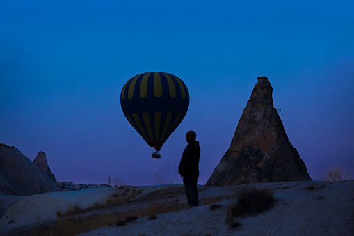 A man and a balloon in Cappadocia at dawn