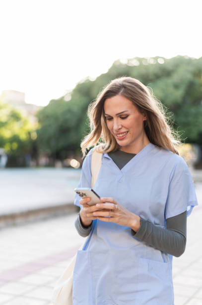 istock Cute nurse using phone in a public park after work 2148186457