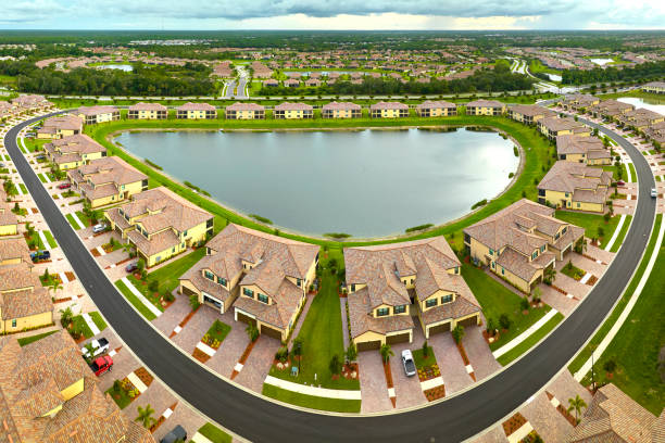 aerial view of tightly located family houses with retention ponds to prevent flooding in florida closed suburban area. real estate development in american suburbs - housing development organized group house real estate foto e immagini stock