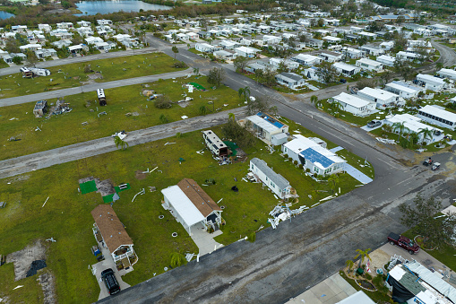 Destroyed RV camper vans and and mobile homes after hurricane in Florida residential area. Consequences of natural disaster.