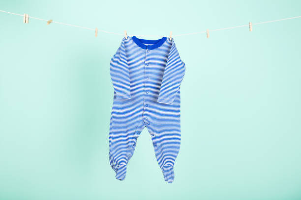 istock Baby clothes hanging on blue background 2148187034