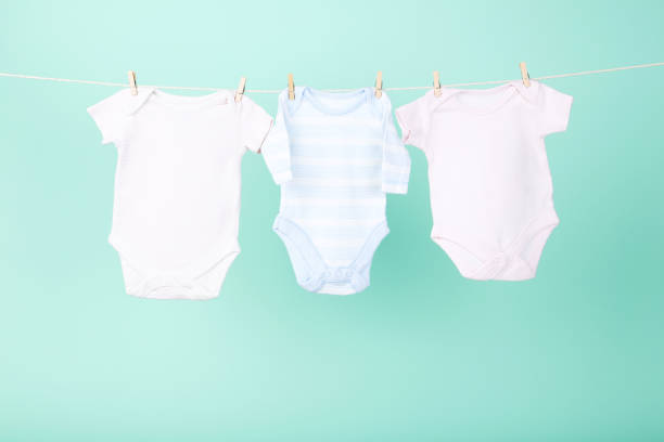 istock Baby clothes hanging on blue background 2148187354