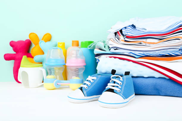 istock Baby clothes with toys and bottles on blue background 2148187781
