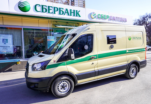 Samara, Russia - April 8, 2023: Ford Transit armored encashment Sberbank van is located at near the Sberbank office. Text in russian: Sberbank