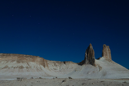 Night scene with the rock pinnacles of Bozzhira valley, Kazakhstan. Ursa major constellation