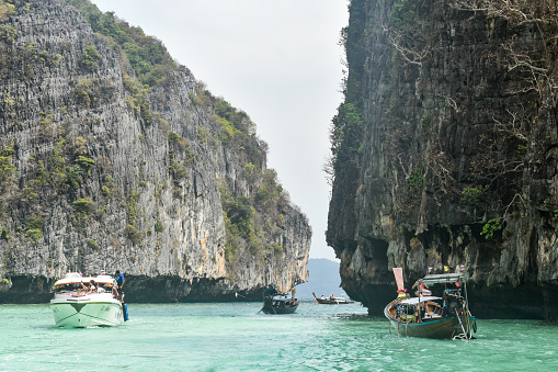 A lagoon near Phi Phi island of Thailand with tourist and multiple boats.