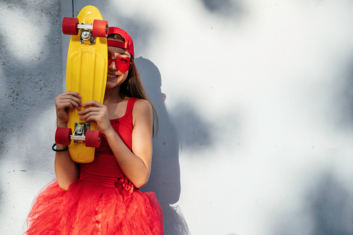 Portrait of beautiful teenage girl with skateboard
. Copy space.