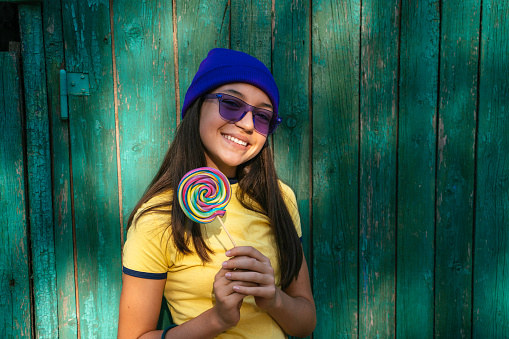 Portrait of beautiful teenage girl with lollipop. Copy space.