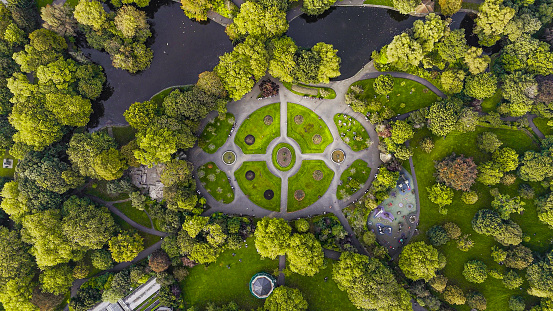 Aerial view of St Stephens Green park, Famous city parks in europe, popular tourist destination in ireland, aerial view of St Stephens Green public park Dublin Merrion Square\n\nSt Stephen's Green is a garden square and public park in Dublin, Ireland. The park's current landscaping was designed by William Sheppard. It was officially reopened to the public by Lord Ardilaun on Tuesday 27 July 1880. The square is adjacent to Grafton Street, one of Dublin's main shopping streets, and a shopping center named after it; In the surrounding streets, there are offices of various public institutions and a stop of one of Dublin's Luas tram lines. . It is often informally referred to as Stephen's Green. At 22 acres (8.9 ha), it is the largest of the parks in Dublin's main Georgian garden squares. Others include nearby Merrion Square and Fitzwilliam Square.\nThe park is rectangular and surrounded by streets that once formed major traffic arteries through Dublin city centre, but traffic management changes implemented in 2004 during the Luas works have greatly reduced traffic volumes. These four neighboring streets are called St Stephen's Green North, St Stephen's Green South, St Stephen's Green East and St Stephen's Green West respectively.