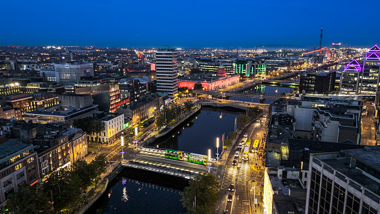 Aerial view of busy city center buildings and traffic at night, Aerial view of the river Liffey and city center Dublin Ireland at night, Aerial view of Dublin skyline and Samuel Beckett Bridge, Aerial view of Dublin city at night, Ireland

Dublin, pronounced is the capital and largest city of Ireland. On a bay at the mouth of the River Liffey, it is in the province of Leinster, bordered on the south by the Dublin Mountains, a part of the Wicklow Mountains range. At the 2016 census it had a population of 1,173,179, while the preliminary results of the 2022 census recorded that County Dublin as a whole had a population of 1,450,701, and that the population of the Greater Dublin Area was over 2 million, or roughly 40% of the Republic of Ireland's total population.