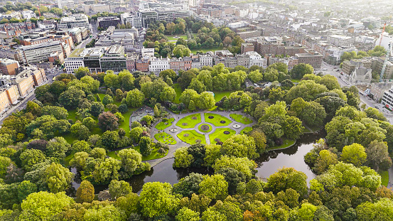 Aerial view of St Stephens Green park, Famous city parks in europe, popular tourist destination in ireland, aerial view of St Stephens Green public park Dublin Merrion Square

St Stephen's Green is a garden square and public park in Dublin, Ireland. The park's current landscaping was designed by William Sheppard. It was officially reopened to the public by Lord Ardilaun on Tuesday 27 July 1880. The square is adjacent to Grafton Street, one of Dublin's main shopping streets, and a shopping center named after it; In the surrounding streets, there are offices of various public institutions and a stop of one of Dublin's Luas tram lines. . It is often informally referred to as Stephen's Green. At 22 acres (8.9 ha), it is the largest of the parks in Dublin's main Georgian garden squares. Others include nearby Merrion Square and Fitzwilliam Square.
The park is rectangular and surrounded by streets that once formed major traffic arteries through Dublin city centre, but traffic management changes implemented in 2004 during the Luas works have greatly reduced traffic volumes. These four neighboring streets are called St Stephen's Green North, St Stephen's Green South, St Stephen's Green East and St Stephen's Green West respectively.