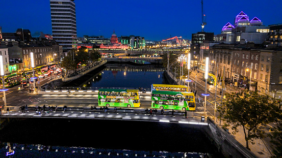 Aerial view of busy city center buildings and traffic at night, Aerial view of the river Liffey and city center Dublin Ireland at night, Aerial view of Dublin skyline and Samuel Beckett Bridge, Aerial view of Dublin city at night, Ireland

Dublin, pronounced is the capital and largest city of Ireland. On a bay at the mouth of the River Liffey, it is in the province of Leinster, bordered on the south by the Dublin Mountains, a part of the Wicklow Mountains range. At the 2016 census it had a population of 1,173,179, while the preliminary results of the 2022 census recorded that County Dublin as a whole had a population of 1,450,701, and that the population of the Greater Dublin Area was over 2 million, or roughly 40% of the Republic of Ireland's total population.