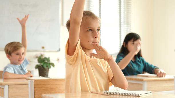 istock Serious student raised hand up to answering question at classroom. Pedagogy. 2148189642