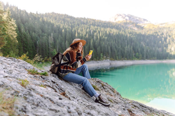 istock Young woman tourist uses a smartphone on the nature. 2148190332