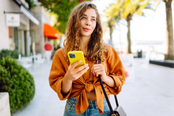 istock Young woman using smartphone at street. 2148191124