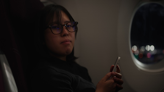 A portrait of an Asian female tourist in an airplane.