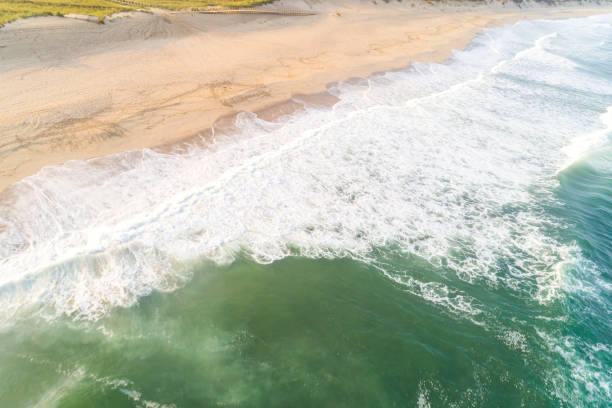 istock waves breaking on a beach in summer aerial view with drone 2148192373