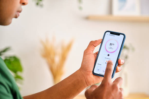 istock A person is holding a phone and controlling the house temperature. 2148192903