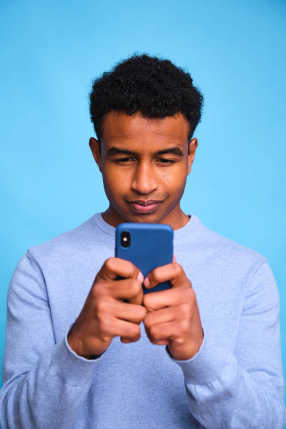 istock Black man is looking at his cell phone. 2148193056