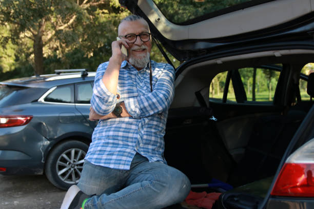 istock Senior modern man in car using phone 2148193651