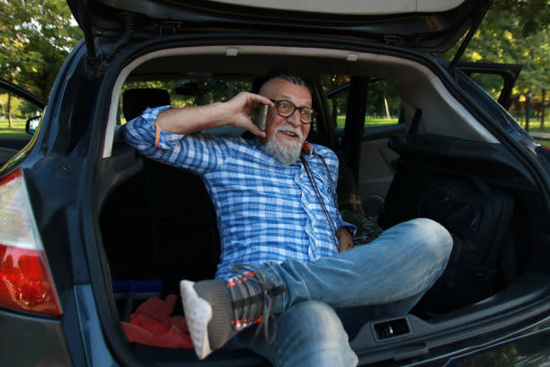 istock Senior modern man in car using phone 2148193676