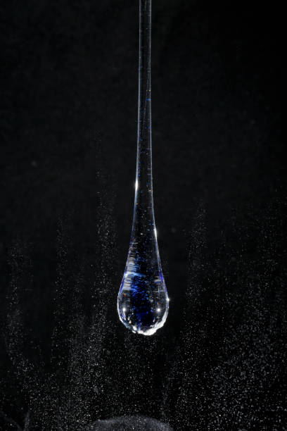 Blue transparent glass drop on black background