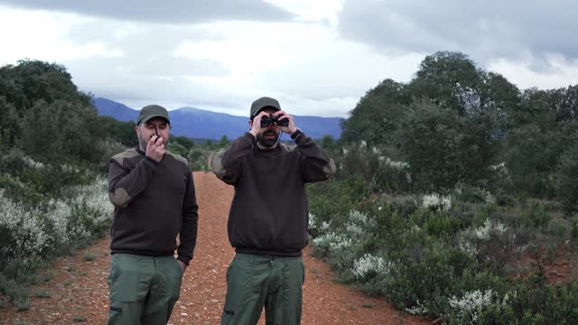 Team of Park Rangers monitoring Wildlife Bush FIres with binoculars and radio - Environmental Conservation Job